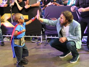 Daniel Bryan greets one of the "Kid Superstars" at WWE Fan Axxess on Saturday. (Steve Argintaru/@SteveTSN photo)