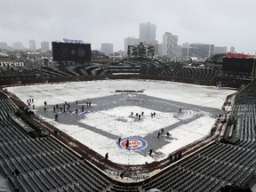 Members of the grounds crew clear snow at Wrigley Field in Chicago, Monday, April 9, 2018. (AP Photo/Nam Y. Huh)