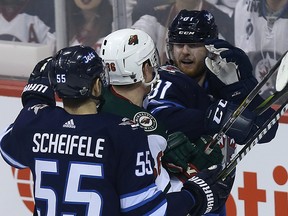 Winnipeg Jets forward Kyle Connor (right) gets into it with Minnesota Wild defenceman Nick Seeler as Mark Scheifele joins the fray during Game 2 of their first-round NHL playoff series in Winnipeg on Friday.