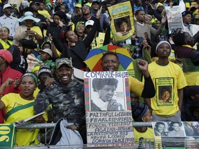 Mourners gather at the Orlando Stadium for the funeral of anti-apartheid icon Winnie Madikizela-Mandela, portrait on placard, in Soweto, South Africa, Saturday, April 14, 2018.