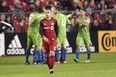 Toronto FC midfielder Ager Aketxe walks away as Seattle Sounders players celebrate their second goal on Wednesday night. (THE CANADIAN PRESS)