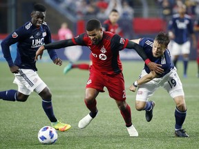 Toronto FC's Jordan Hamilton and New England Revolution's Antonio Delamea Mlinar battle for the ball during Saturday night's game. (AP PHOTO)