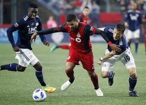 Toronto FC's Jordan Hamilton and New England Revolution's Antonio Delamea Mlinar battle for the ball during Saturday night's game. (AP PHOTO)