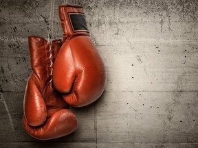 Boxing gloves hanging on concrete wall (Getty Images)