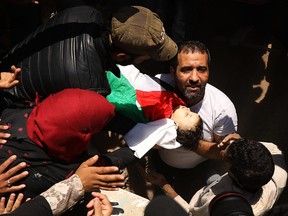 The body of eight-month-old Leila Anwar Ghandoor, who died in hospital from tear gas inhalation, is placed into a grave on May 15, 2018 in Gaza City, Gaza. (Spencer Platt/Getty Images)