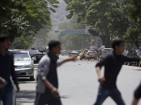 Afghans run from the site of a suicide attack, in the centre of Kabul, Afghanistan, Wednesday, May 9, 2018.