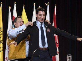 Prime Minister Justin Trudeau receives an Assembly of First Nations jacket as a gift from AFN National Chief Perry Bellegarde, after his speech at the AFN's Special Chiefs Assembly in Gatineau, Que., on Wednesday, May 2, 2018. (Justin Tang/The Canadian Press)