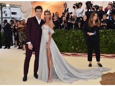 Hailey Baldwin (R) and Shawn Mendes arrive for the 2018 Met Gala on May 7, 2018, at the Metropolitan Museum of Art in New York. The Gala raises money for the Metropolitan Museum of Arts Costume Institute. The Gala's 2018 theme is Heavenly Bodies: Fashion and the Catholic Imagination.