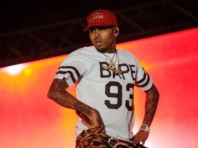 This file photo taken on June 26, 2015 shows singer Chris Brown performing during a free concert in Champ de Mars, downtown Port-au-Prince, Haiti.  A Los Angeles woman filed a lawsuit on Wednesday, May 9, 2018 against Chris Brown and a fellow rapper, alleging she was repeatedly raped and sexually assaulted at Brown's home during a drug- and alcohol-fueled party last year. The woman, identified only as Jane Doe, said she was lured to the singer's house following a concert at a nightclub on February 23, 2017 and was raped several times by Lowell Grissom, who performs under the name Young Lo.