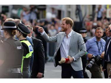 Britain's Prince Harry (C) greets well-wishers on the street outside Windor Castle in Windsor on May 18, 2018, the eve of Prince Harry's royal wedding to US actress Meghan Markle.  Britain's Prince Harry and US actress Meghan Markle will marry on May 19 at St George's Chapel in Windsor Castle.