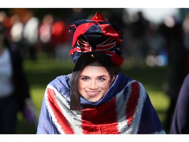 A well-wisher wears a mask depicting an image of Meghan Markle as they walk along the Long Walk leading to Windsor Castle ahead of the wedding and carriage procession of Britain's Prince Harry and Meghan Markle in Windsor, on May 19, 2018.
