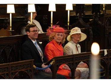 Jack Brooksbank (L) and Emilie van Cutsem (C) take their seats ahead of the wedding ceremony of Britain's Prince Harry, Duke of Sussex and US actress Meghan Markle in St George's Chapel, Windsor Castle, in Windsor, on May 19, 2018.