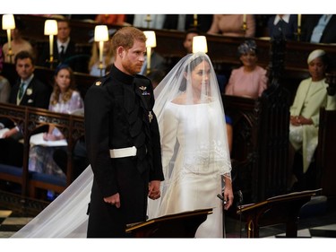 Britain's Prince Harry, Duke of Sussex (L) and US fiancee of Britain's Prince Harry Meghan Markle stand together for their wedding in St George's Chapel, Windsor Castle, in Windsor, on May 19, 2018.