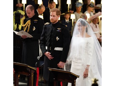 Britain's Prince Harry, Duke of Sussex (C) and US actress Meghan Markle (R) stand together at the altar in St George's Chapel, Windsor Castle, in Windsor, on May 19, 2018 during their wedding ceremony.