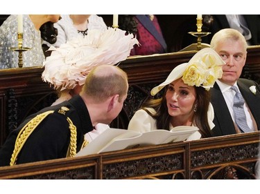 Britain's Prince William, Duke of Cambridge, (L) speaks with his wife, Britain's Catherine, Duchess of Cambridge during the wedding ceremony of Britain's Prince Harry, Duke of Sussex and US actress Meghan Markle in St George's Chapel, Windsor Castle, in Windsor, on May 19, 2018.