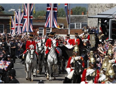 Britain's Prince Harry, Duke of Sussex and his wife Meghan, Duchess of Sussex travel in the Ascot Landau Carriage during their carriage procession on the High Street in Windsor, on May 19, 2018 after their wedding ceremony.