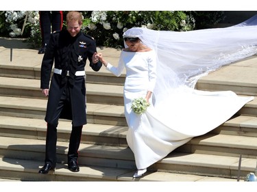 Britain's Prince Harry, Duke of Sussex and his wife Meghan, Duchess of Sussex emerge from the West Door of St George's Chapel, Windsor Castle, in Windsor, on May 19, 2018 after their wedding ceremony.