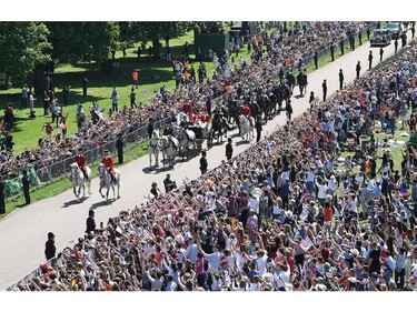 Britain's Prince Harry, Duke of Sussex and his wife Meghan, Duchess of Sussex wave from the Ascot Landau Carriage during their carriage procession on the Long Walk as they head back towards Windsor Castle in Windsor, on May 19, 2018 after their wedding ceremony.