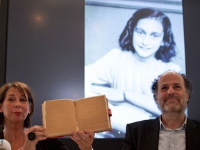 Teresien da Silva, left, and Ronald Leopold of the Anne Frank Foundation show a facsimile of Anne Frank's diary with two pages taped off during a press conference at the foundation's office in Amsterdam, Netherlands, Tuesday, May 15, 2018.