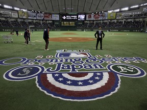 In this March 28, 2012, file photo, ground staff work prior to the American League season opening game between the Oakland Athletics and the Seattle Mariners at Tokyo Dome in Tokyo.  (AP Photo/Shizuo Kambayashi, File)
