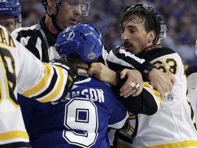 Bruins left wing Brad Marchand (right) and  Lightning centre Tyler Johnson (9) scrap during NHL playoff action in Tampa, Fla., Monday, April 30, 2018