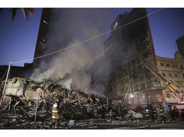 Firefighters work in the the rubble of a building that caught fire and collapsed in Sao Paulo, Brazil, Tuesday, May 1, 2018.