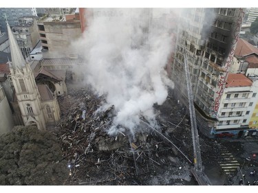 Firefighters work in the the rubble of a building that caught fire and collapsed in Sao Paulo, Brazil, Tuesday, May 1, 2018.