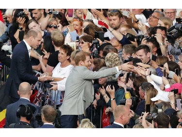 Britain's Prince William, top left, and Prince Harry, center, greet crowds in Windsor, near London, England, Friday, May 18, 2018. Preparations continue in Windsor ahead of the royal wedding of Britain's Prince Harry and Meghan Markle on Saturday May 19.