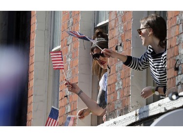 Women wave British and American flags prior to the wedding ceremony of Prince Harry and Meghan Markle at St. George's Chapel in Windsor Castle in Windsor, near London, England, Saturday, May 19, 2018.