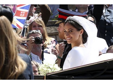 Britain's Prince Harry and Meghan Markle leave in an open carriage after their wedding ceremony  at St. George's Chapel in Windsor Castle in Windsor, near London, England, Saturday, May 19, 2018. (Chris Radburn/pool photo via AP) ORG XMIT: RWW214