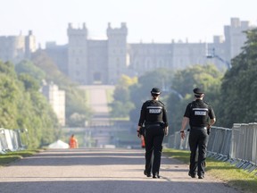 Two police officers make their way down the Long Walk in Windsor, England as the clean-up continues after the royal wedding of Prince Harry and Meghan Markle, Sunday May 20, 2018.