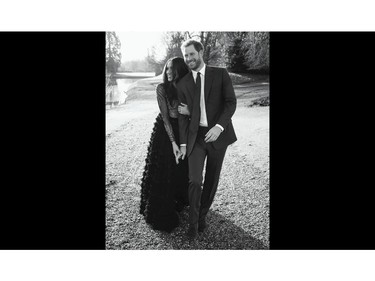 In this photo released by Kensington Palace on Thursday, Dec. 21, 2017, Britain's Prince Harry and Meghan Markle pose an official engagement photo, at Frogmore House, in Windsor, England.