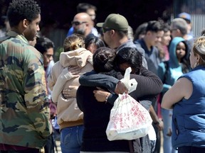 Students are reunited with family members outside Highland High School in Palmdale as Sheriff took the school off lockdown on Friday, May 11, 2018. A 14-year-old used a rifle to shoot a classmate in the arm Friday at their high school in California and dumped the gun in the desert before he was caught in a shopping center, authorities said.