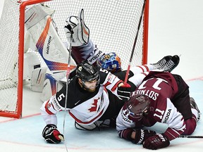 Latvia's goalkeeper Mattis Kivlenieks gives up a goal as Canada's Aaron Ekblad and Latvia's Kristaps Sotnieks fall during the world championship at the Jyske Bank Boxen in Herning, Denmark, on May 14, 2018. (Getty Images)