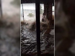 In this screenshot, waves crash into the home of Dawn Burke as flood waters ravage New Brunswick.