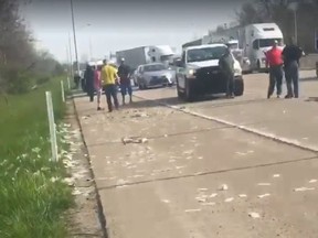 In this screenshot, bystanders and police arrive on the scene after a Brinks truck's load flew out of the vehicle on I-70 on May 2, 2018.
