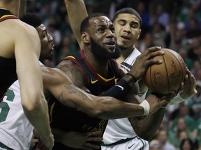 Cleveland Cavaliers forward LeBron James drives against Boston Celtics guard Marcus Smart, left, and forward Jayson Tatum, right, during Game 5 of the NBA Eastern Conference finals Wednesday, May 23, 2018, in Boston.
