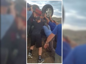 In this screengrab of a video posted on Facebook, Boise Black Knights team members from Idaho are seen trying to flip over an overturned car to rescue two people after a crash in Oregon. (Regan Magill/Facebook)