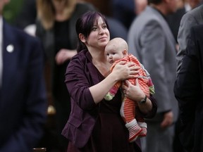 NDP Member of Parliament Christine Moore carries her daughter Daphnee after casting her ballot for a new Speaker in the House of Commons on Parliament Hill in Ottawa, Dec. 3, 2015.
