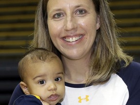 In an Aug. 30, 2017, photo, California women's basketball coach Lindsay Gottlieb holds her then-6-month-old son, Jordan, during NCAA college basketball practice on the campus. (AP Photo/Marcio Jose Sanchez)