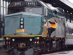A Via Rail employee climbs aboard a locomotive at the train station in Ottawa on December 3, 2012.
