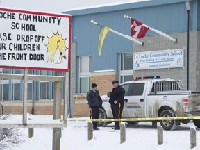 Members of the RCMP stand outside the La Loche Community School in La Loche, Sask. Monday, Jan. 25, 2016. (THE CANADIAN PRESS/Jonathan Hayward)