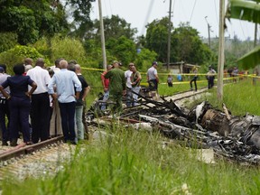 Rescue and search workers on the site where a Cuban airliner with more than 100 passengers on board plummeted into a yuca field just after takeoff from the international airport in Havana, Cuba, Friday, May 18, 2018.