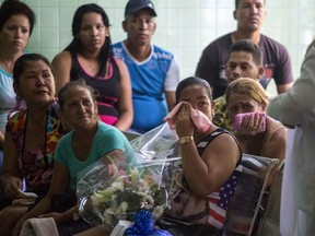 Grieving relatives of passengers who perished in Cuba's worst aviation disaster wait at the morgue for the identification of the bodies in Havana, Cuba, Sunday, May 20, 2018. (AP Photo/Desmond Boylan)