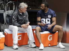 Seattle Seahawks wide receiver Doug Baldwin, right, talks with head coach Pete Carroll following their practice, Thursday, May 24, 2018, in Renton, Wash. (AP Photo/Ted S. Warren)