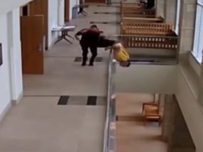 Security footage shows Christopher Rudd darting from a courtroom and flipping over a balcony rail before falling to the floor below. (YouTube)