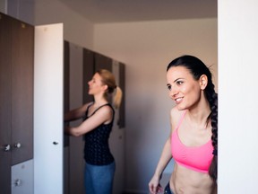 In this stock photo, a pair of women get changed in a gym locker room.