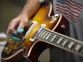 A Gibson Guitar Corp. employee tests the sound of a guitar at the company's factory in Nashville, Tennessee, U.S., on Friday, Oct. 7, 2011.