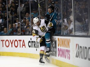 Brenden Dillon of the San Jose Sharks is checked by William Carrier of the Vegas Golden Knights during Game 3 at SAP Center on April 30, 2018