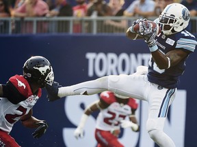 Toronto Argonauts slotback S.J. Green (19) catches a touchdown pass in front of Calgary Stampeders defensive back Joe Burnett (24) during CFL action in Toronto on Thursday, August 3, 2017. (THE CANADIAN PRESS/Nathan Denette)